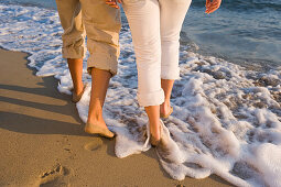 Junges Paar gehen am Strand, Beine sichtbar, Apulien, Italien