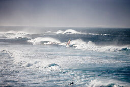 Windsurfer und Riesenwellen in der Nähe von Hookipa Beach, Maui, Hawaii, USA