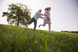 Couple running on meadow