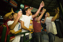 Spectators applauding during a Thai boxing competition, Lumphini Stadium, Bangkok, Thailand