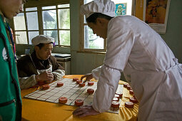 kitchen staff of a small restaurant next to the path play chinese Chess, Emei Shan Mountains, China, Asia, World Heritage Site, UNESCO