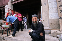 Abbot sitting in front of monastery and hostel Cui Yun Gong, Hua Shan, Shaanxi province, China, Asia