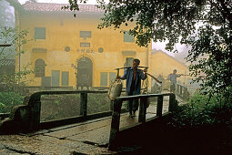 Porters carrying building material in front of Tianchi monastery at the village Jiuhuashan, Anhui province, China, Asia