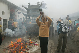 Pilgrims burning incense sticks in front of Longevity monastery, Jiuhua Shan, Anhui province, China, Asia