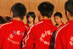 Kungfu Training, Schule, Song Shan,Mädchen, junge Frau, Kungfu Morgenübung einer Kungfu Klasse neben dem Shaolin Kloster, Traingsanzug rot, Songshan, Provinz Henan, China, Asien