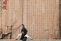 Taoistischer Mönch Zhang Qingren demonstriert die hohe Kunst des Taichi, 24-Figuren Zyklus vor berühmter Inschrift in Felswand, Gedicht des Tang Kaisers Li Longji, Xuanzong, Taishan, Provinz Shandong, UNESCO Weltkulturerbe, China, Asien