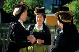 Three women in dirndl dresses talking to each other, pilgrimage to Raiten, Schleching, Chiemgau, Upper Bavaria, Bavaria, Germany