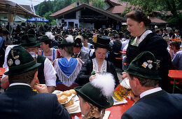 Young women in dirndl dresses and young men in traditional dress in a beer garden, pilgrimage to Raiten, Schleching, Chiemgau, Upper Bavaria, Bavaria, Germany
