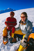 A couple having a rest after snowshoeing, Serfaus, Tyrol, Austria