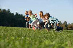Children running across a field, children's birthday party