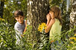 Mädchen und Junge spielen Verstecken, Kindergeburtstag