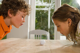 Ein Mädchen und ein Junge spielen Wattebausch Blasen, Kindergeburtstag