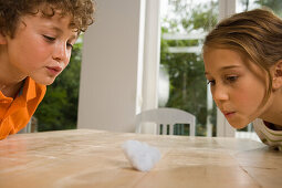 Girl and boy playing Cotton Wool Blowing, children's birthday party