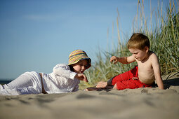 Girl and boy playing at sandy beach of Baltic Sea, Travemuende Bay, Schleswig-Holstein, Germany