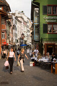 Two women strolling over Augustinergasse, passing a pavement cafe, Zurich, Canton Zurich, Switzerland