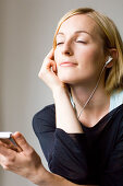 Young woman listening to music about earphones