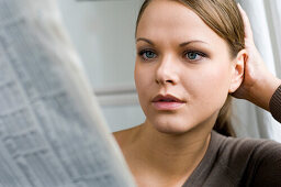 Young woman reading newspaper