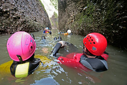 Men glinding through river, swim and hike canyon Raebloch, Emmental valley, Canton of Bern, Switzerland, MR