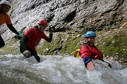 Men glinding through river, swim and hike canyon Raebloch, Emmental valley, Canton of Bern, Switzerland, MR
