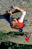 Junge Frau klettert an Felswand, Urner Alpen, Kanton Uri, Schweiz, MR