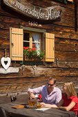 Junges Paar trinkt Cider, Lammersdorfer Hütte (1650 m), Lammersdorf bei Millstatt, Kärnten, Österreich