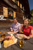 Couple eating a Jause (snack) at Lammersdorfer Hütte (1650 m), Lammersdorf near Millstatt, Carinthia, Austria