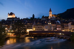 View over river Aare with mill slucie to Thun Castle and town church in the evening, Thun (largest garrison town of Switzerland), Bernese Oberland (highlands), Canton of Bern, Switzerland