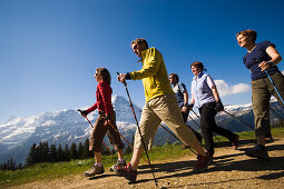 Group of people nordic walking at Bussalp 1800 m, view to Eiger North Face 3970 m, Grindelwald, Bernese Oberland, Canton of Bern, Switzerland