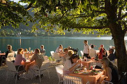 People sitting in the open air area of a restaurant at Lake Fuschl in the evening, Fuschl am See, Salzkammergut, Salzburg, Austria