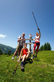 Drei Wanderer rasten bei einem Wegweiser, Bichlalm 1731 m, Grossarltal, Salzburg, Österreich