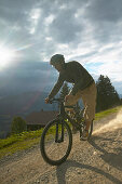 Mountainbiker fährt über Feldweg, Simmental, Wistätthorn (2362 m) im Hintergrund, Lenk, Berner Oberland, Kanton Bern, Schweiz, MR