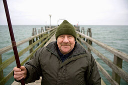 Man with fishing rod on pear at Baltic Sea, Mecklenburg-Western Pomerania, Germany