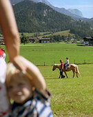 Ausritt für Tochter, Mutter und Sohn sehen zu, bei Leogang, Salzburg, Östereich