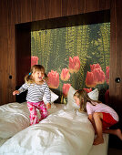 Two girls jumping around on a bed, Hotel Room, Spa Hotel Seehotel Neuklostersee, Mecklenburg - Western Pomerania, Germany