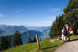 Mature adult couple looking over Lake Lucerne to mount Burgenstock and mount Pilatus (2132 m), from mount Rigi (1797 m, Queen of the Mountains), Rigi-Kaltbad, Canton of Schwyz, Switzerland