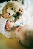 Baby playing with teddy bear