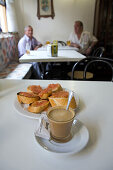 Espresso coffee with milk in a glass, a cortado, white bread with tomatoes, tapas, Spanish restaurant, Valencia, Spain