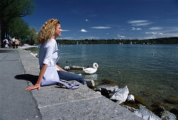 Young woman sitting at Lake Starnberg, Bavaria, Germany
