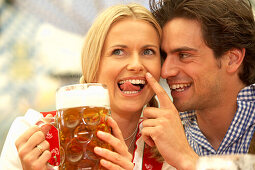 Couple enjoying a liter of beer in a beer tent