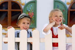 Zwei Kinder (3-5 Jahre) stehen hinter einem Zaun