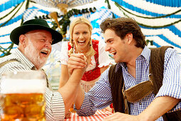 Two men arm wrestling in a beer tent