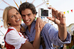 Mid adult couple photographing themselves with a digital camera