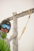 Skier standing next to symbolic gallows for poachers, Castle Mountain ski resort, Southern Alberta, Canada
