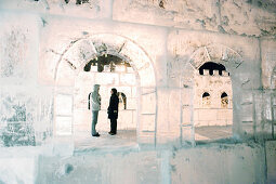 A couple in an ice castle at Lake Louise at night, Alberta, Canada