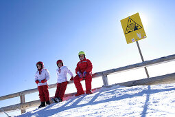 Three children having a rest after skiing, Glacier Cable Car, Upper Station, Schnalstal, South Tyrol, Italy