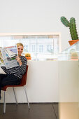 Junge Frau liest Zeitung in einem Café, Luxemburg