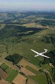 Aerial photo of a glider airplane over Rhoen Region, Near Wasserkuppe Mountain, Rhoen, Hesse, Germany