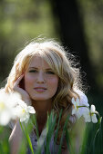 Young woman lying on grass smiling at camera, Icking, Bavaria, Germany