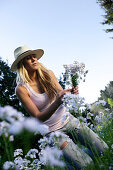 Young woman picking flowers, Icking, Bavaria, Germany