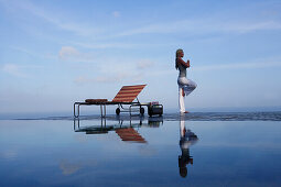 Junge Frau meditiert am Pool, nahe Uluwatu, Bali, Indonesien